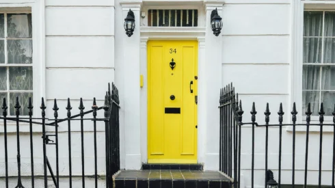 Yellow front door with steps and railings - part of Webmart's real estate marketing case study.