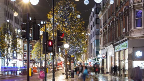 High street with shops lit up at night - Webmart's 33% print savings case study.
