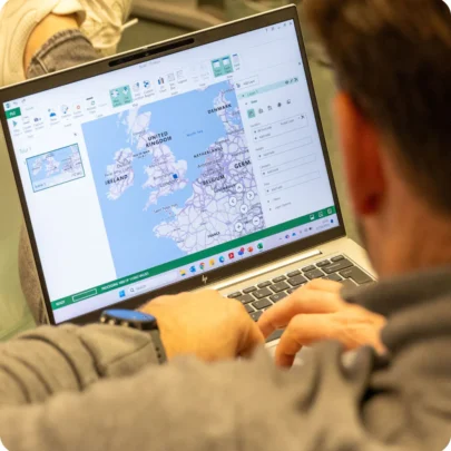 Webmarteer Darryl works on his laptop which shows a map of the UK and north western Europe as he works on a clients marketing strategy for their integrated marketing activity