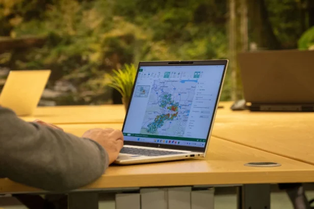 A Webmarteer works at a laptop that shows a heatmap of the UK as part of a direct mail campaign targeting a new audience data profile
