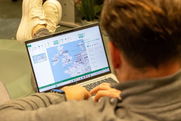 A client strategist at Webmart works on a laptop that shows a map of the UK and Northern Europe as they work on identifying a new audience for a direct mail marketing campaign