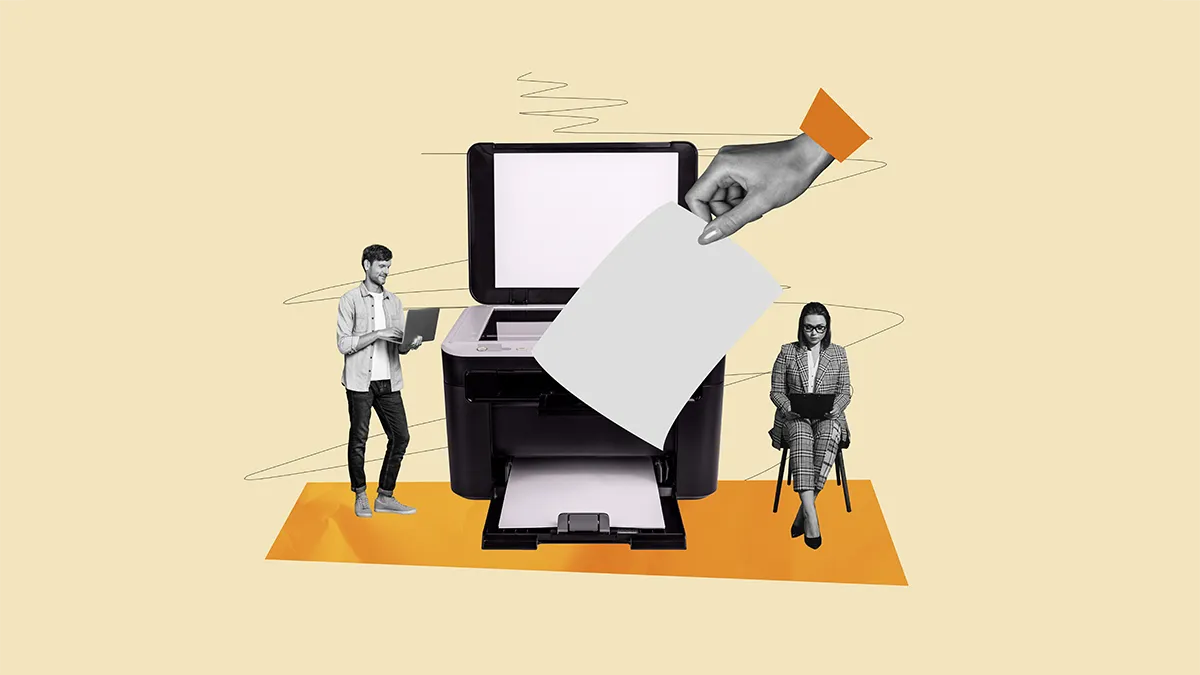 two people sit either side of a large printer