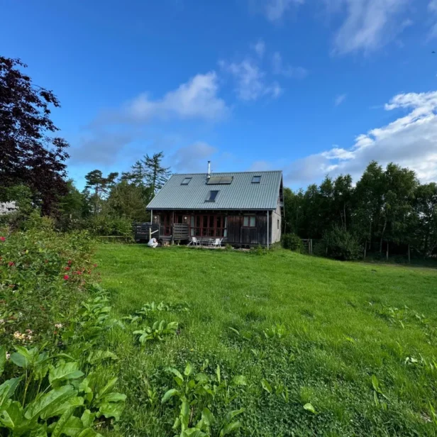 a wooden lodge called Grange Woodhouse AKA the Oxygen Farm Lodge in Scotland on a sunny day