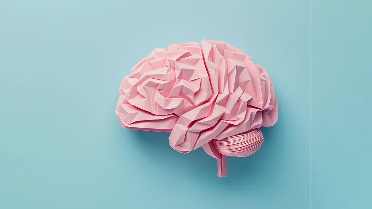 A pink brain over a blue background illustrates psychology to promote a marketing and design blog article